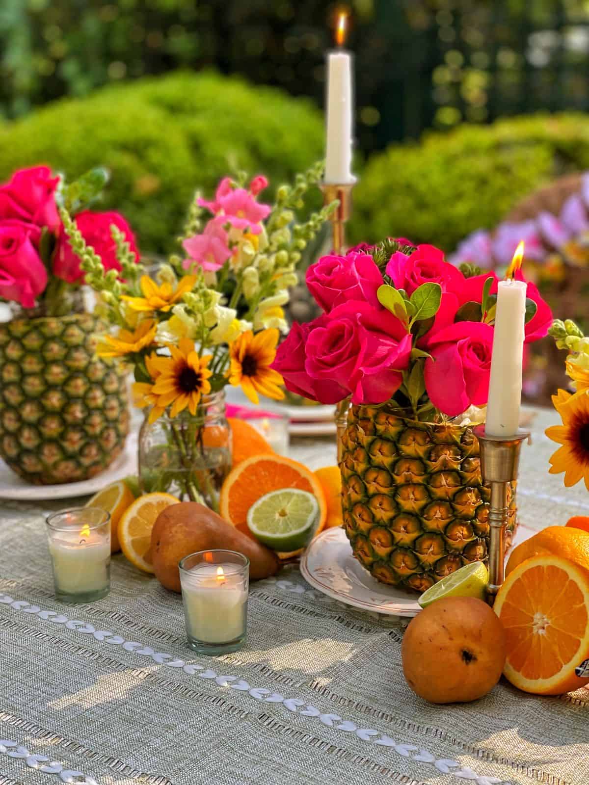 Tropical floral and fruit table detail with candlelight