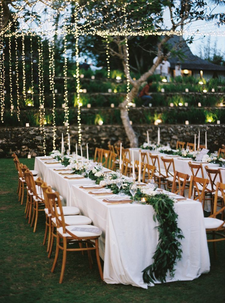 Reception tables under hanging string lights at dusk
